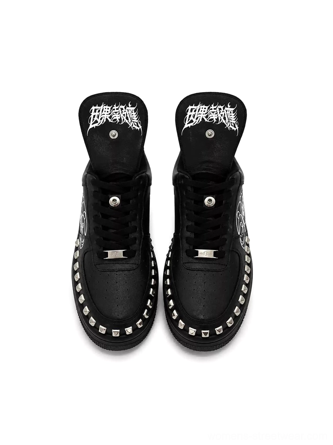 Black studded low top leather sneakers with gothic script foldover tongues, metallic midsole details and alternative streetwear styling
