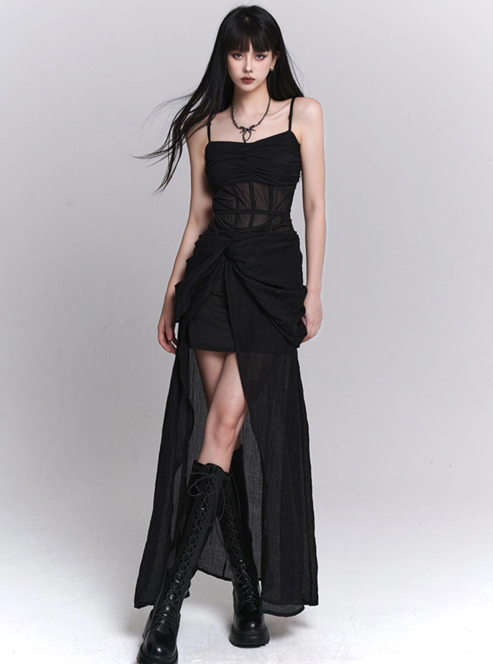 Black gothic slip dress front view with sheer corset waist, asymmetrical draped skirt, high-low split hem, and layered sheer overlay