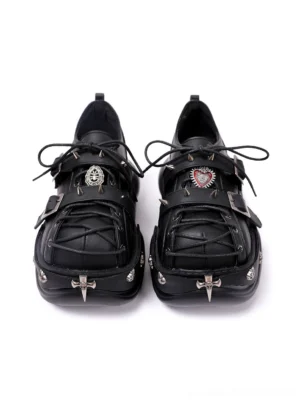 Pair of black gothic Y2K platform sneakers viewed from above with decorative metal emblems, cross toe details, strap-lace styling, and chunky outsole