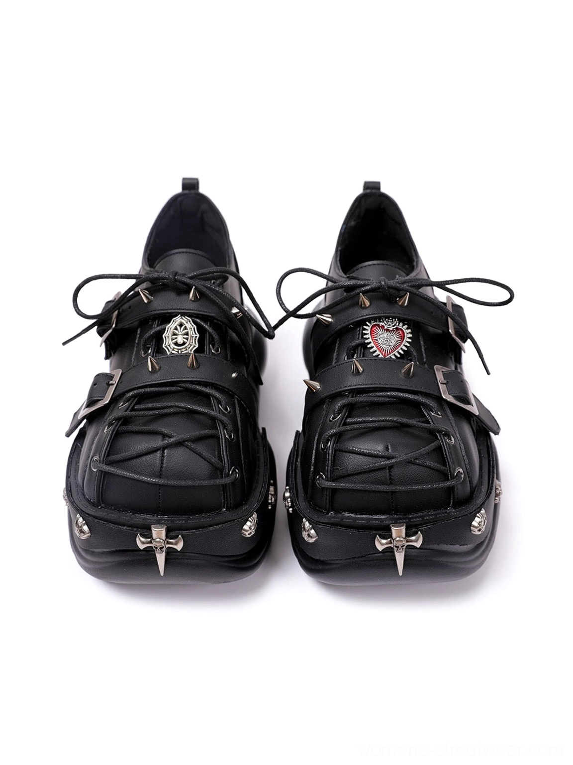 Pair of black gothic Y2K platform sneakers viewed from above with decorative metal emblems, cross toe details, strap-lace styling, and chunky outsole