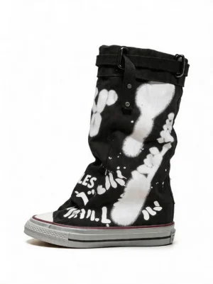 Black graffiti print mid-calf canvas boots with white urban artwork, rolled buckle cuff, lace-up sneaker construction, and vintage rubber outsole