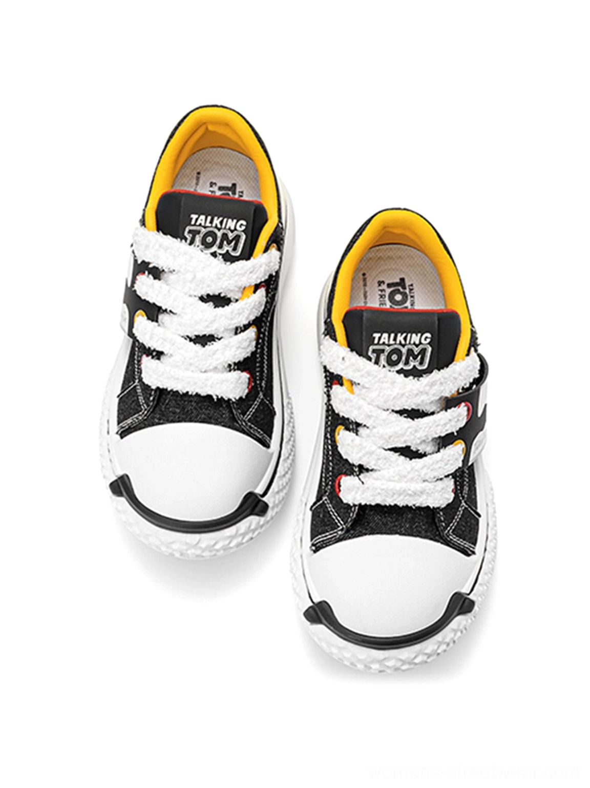 Front overhead view of black graphic chunky sneakers with white laces, rounded toes, thick soles, and bright inner collar detail