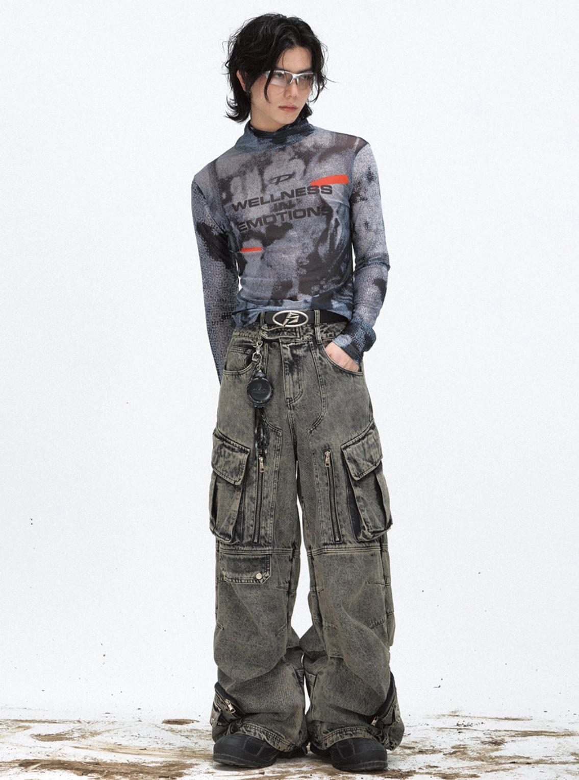 Fitted black graphic mesh turtleneck top with long sleeves paired with loose gray cargo denim in an edgy streetwear outfit