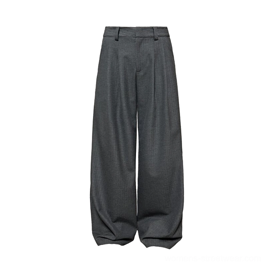 Flat lay front view of black and gray wide-leg streetwear trousers with a structured waistband, front pleats, and dark charcoal suiting material