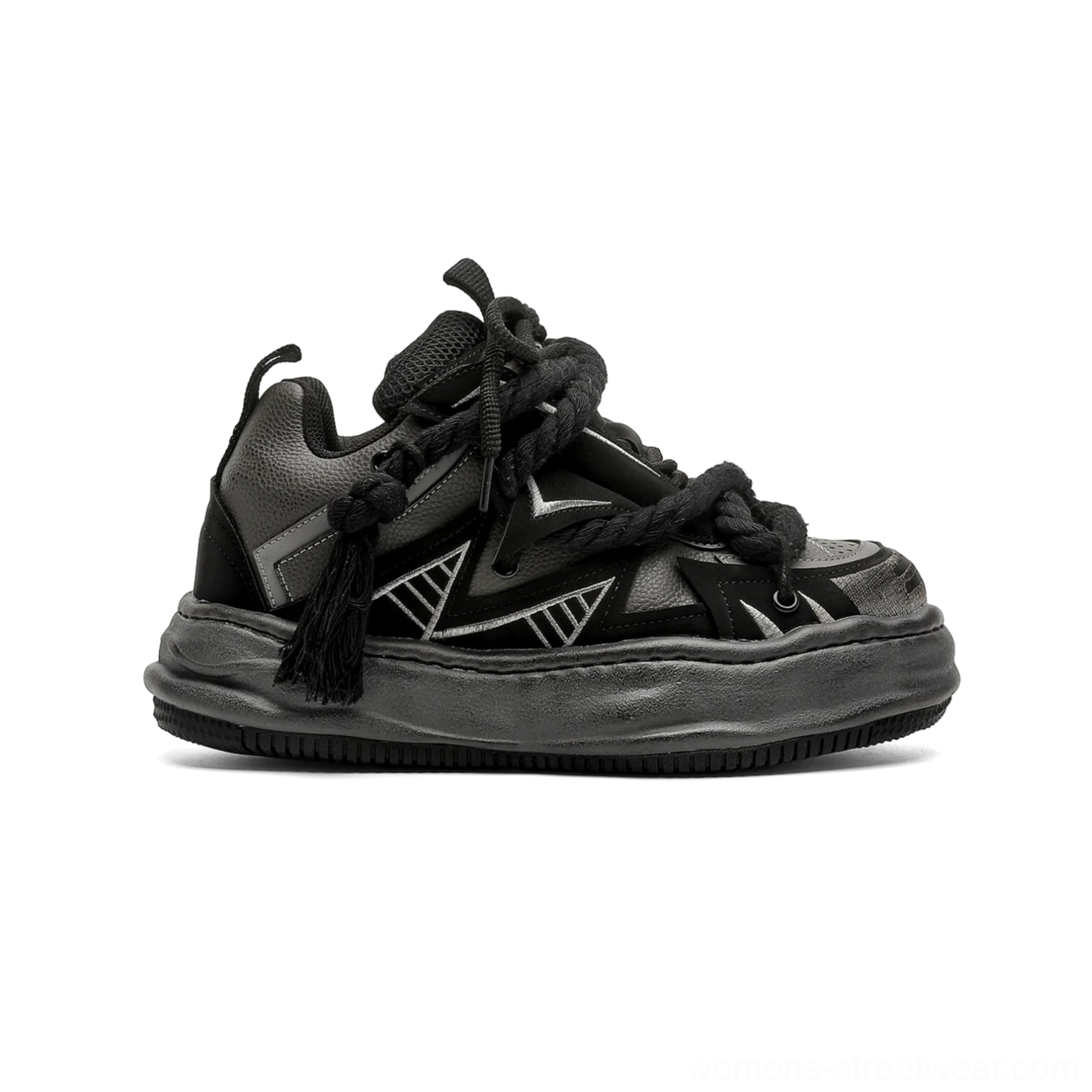 Black and grey distressed rope-lace chunky sneakers shown from the rear side with silver geometric details, oversized braided rope laces, a bulky low-top silhouette, and a worn platform outsole
