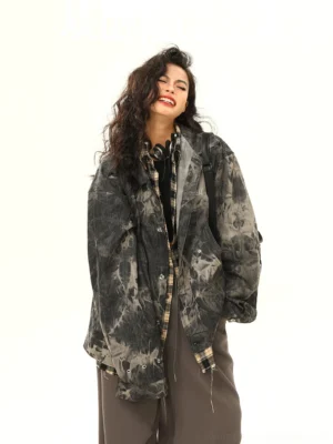 Side front view of black grey acid wash tie-dye grunge denim jacket with relaxed oversized streetwear fit