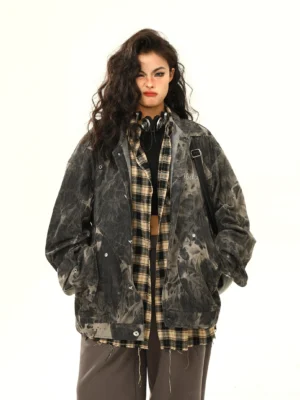 Front view of black grey tie-dye oversized grunge denim jacket styled on female model in white studio