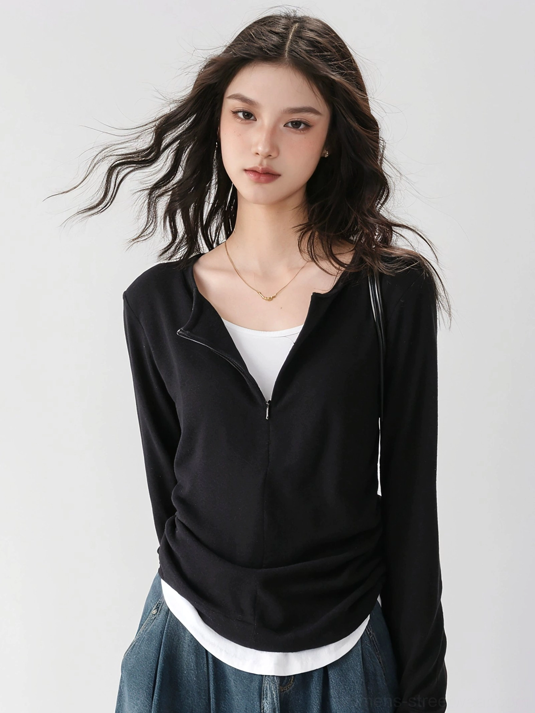 Close-up of black slim-fit half-zip mock neck ribbed knit base layer top with stand collar and layered two-piece effect