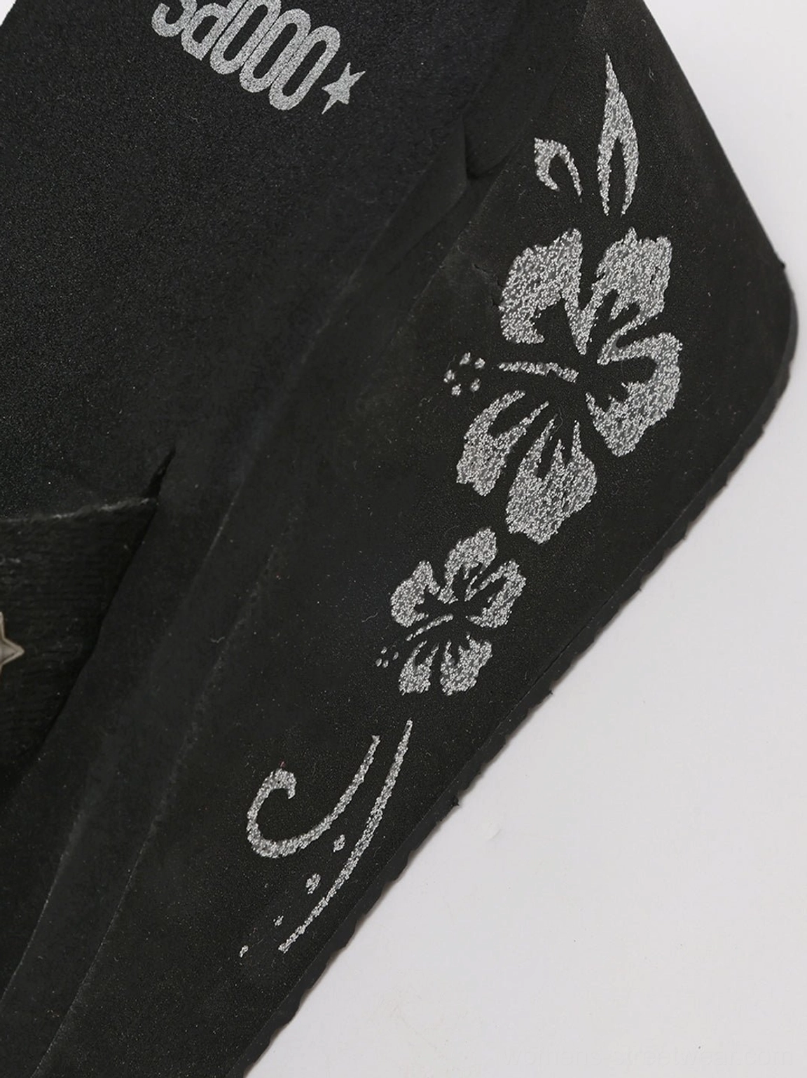 Black hibiscus embroidered platform wedge flip-flops silver star embellished strap close-up