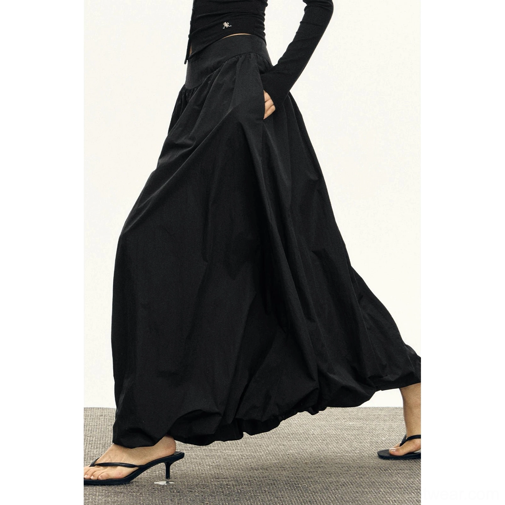 Black high waisted bubble maxi skirt dynamic side view with flowing pleated balloon silhouette
