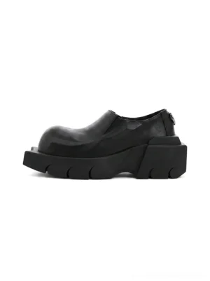 Black horn-detail leather platform derby shoes shown in side profile with smooth matte cow leather, chunky block sole, and rounded square toe
