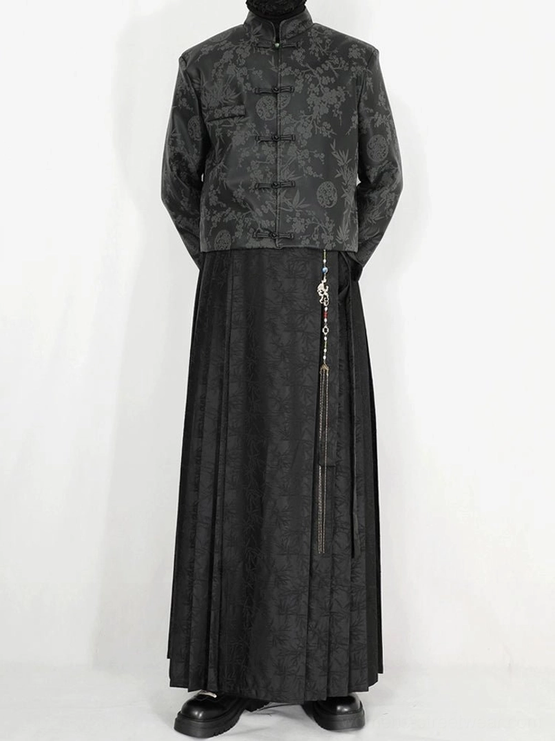 Back side view of black jacquard pleated maxi skirt with flowing floor-length silhouette and waist tassel chain