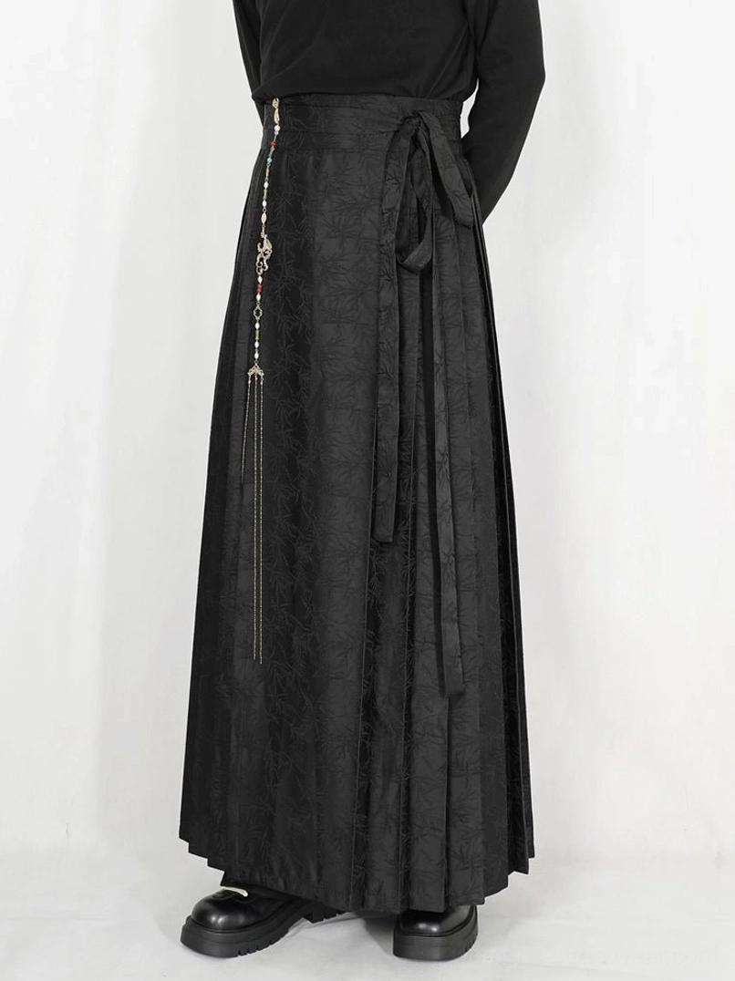 Black jacquard pleated maxi skirt with side tie sash and tassel chain styled with black turtleneck and platform loafers