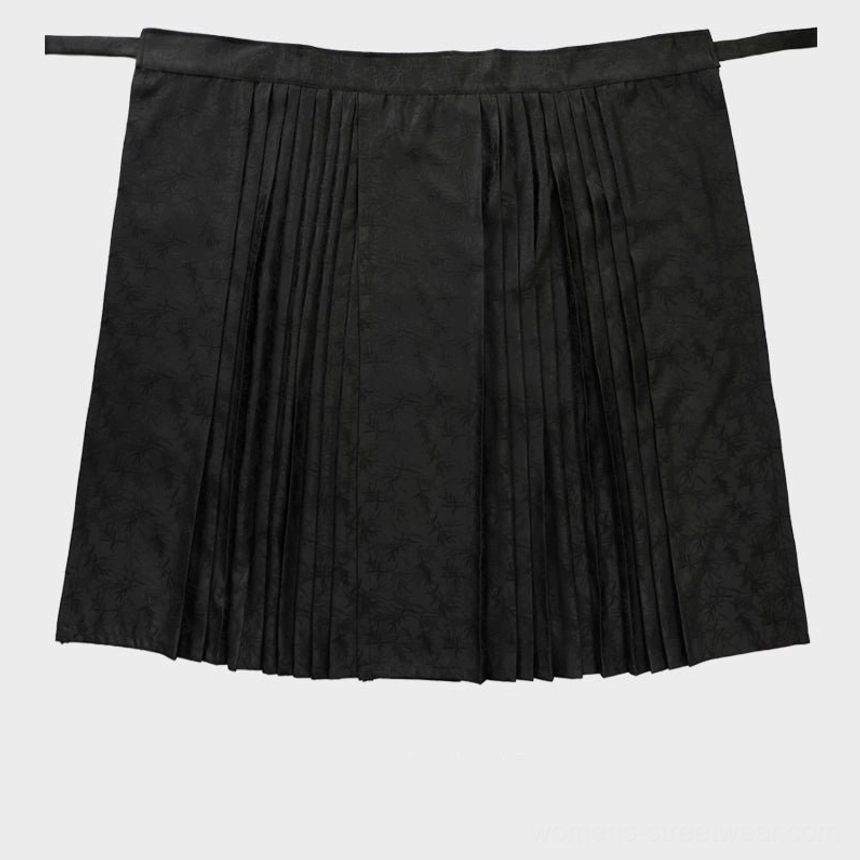 Black jacquard pleated maxi skirt with tassel chain and side tie waist in full-length streetwear silhouette
