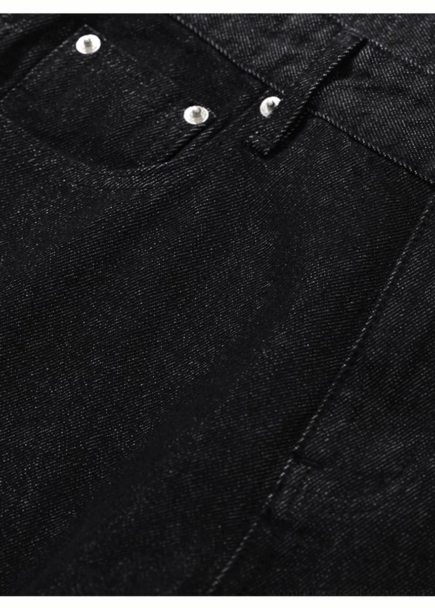 Detailed close-up of classic black jeans rear pocket with reinforced silver metal rivets
