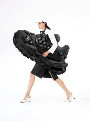 Fashion styling view of oversized black keyboard chunky platform sneakers worn with a white blazer, black mini skirt, and contemporary Y2K streetwear outfit