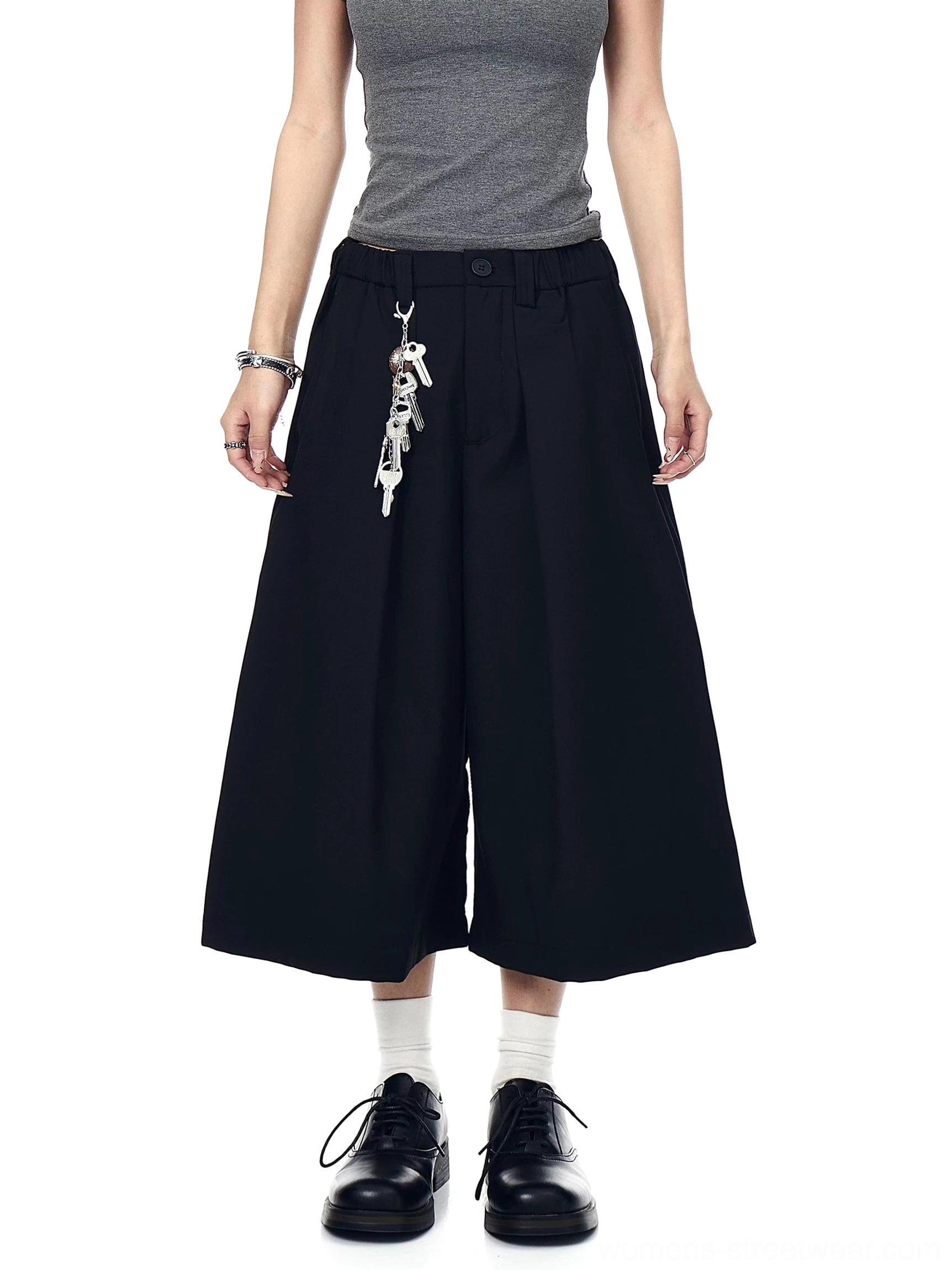 Black keyring pleated wide-leg culotte trousers shown in a full front view with a clean tailored fit and cropped silhouette