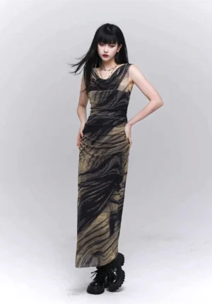 Three-quarter front view of a ruched black and khaki marble print mesh maxi dress with sheer fabric, cowl neckline, fitted silhouette, and black combat boots