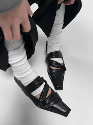 Black square-toe leather flats styled with white ribbed socks and loose black trousers in a modern Seoul streetwear outfit