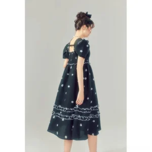 Back view of a black Korean streetwear midi dress with puff sleeves, shirred bodice, floral detailing, and layered ruffle skirt