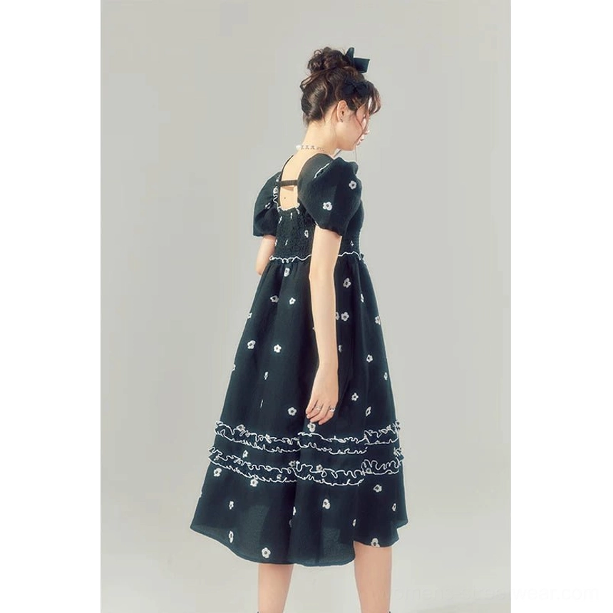 Back view of a black Korean streetwear midi dress with puff sleeves, shirred bodice, floral detailing, and layered ruffle skirt