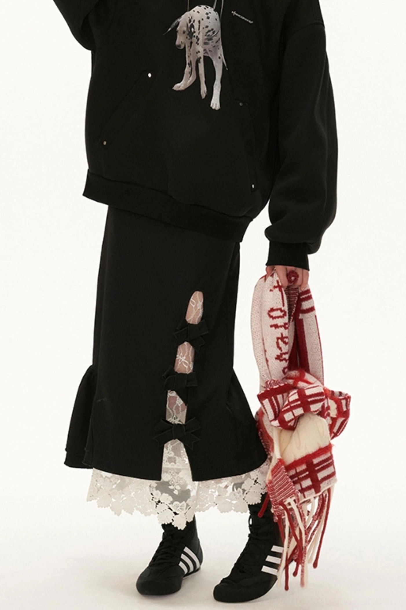 Black lace bow side-slit ruffle hem midi skirt styled with a graphic hoodie, casual sneakers, and red plaid accessory for Korean streetwear