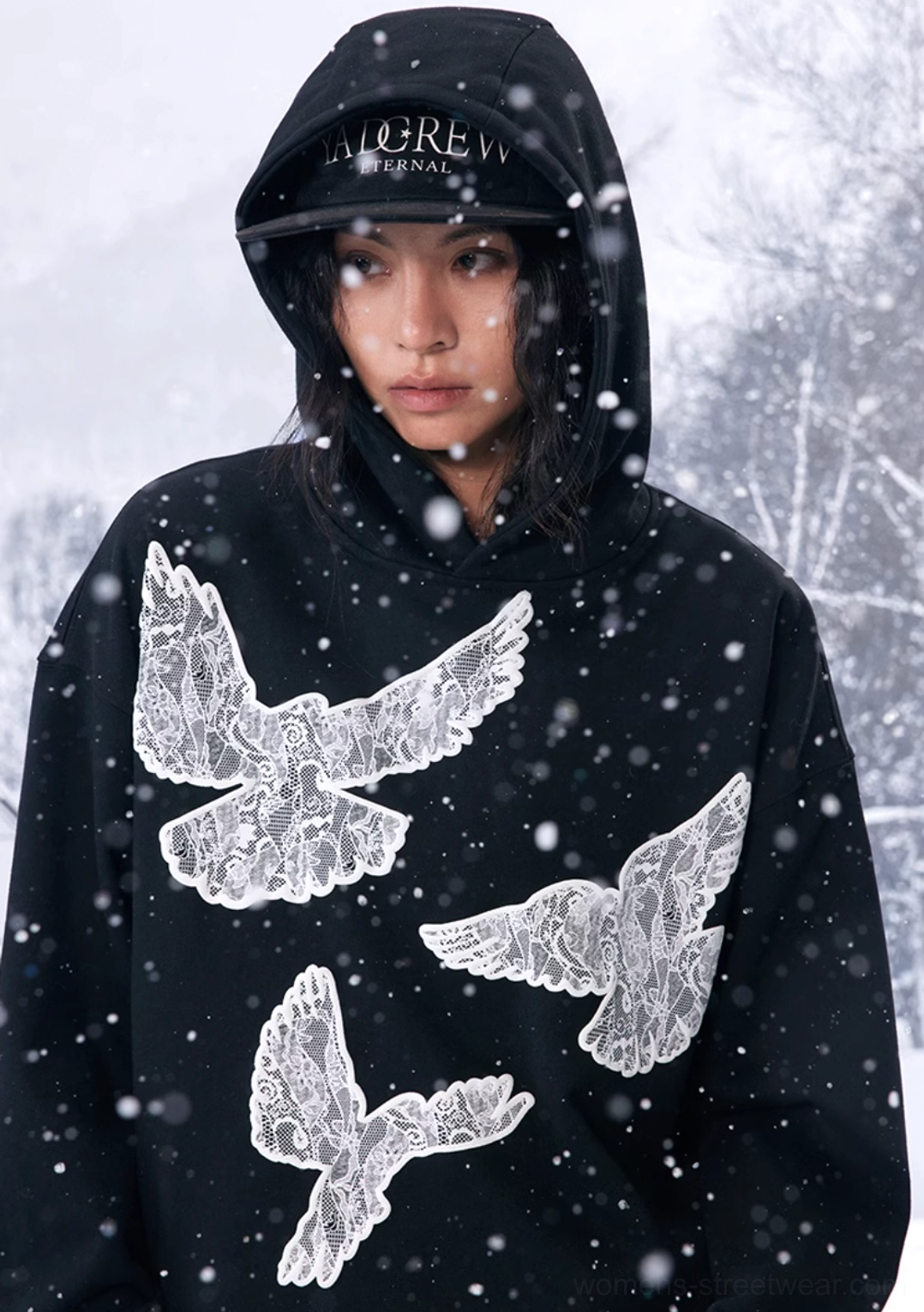 Close-up front view of a black lace dove hoodie showing the textured dove graphics, attached hood and detailed sleeve styling