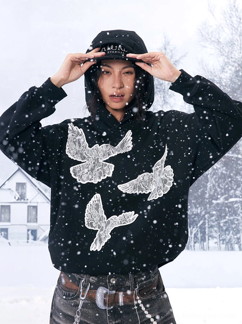 Black lace dove hoodie styled in a snowy outdoor setting with vintage denim, a cap and contemporary Y2K streetwear details