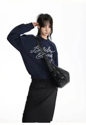 Black faux leather lace-up crescent hobo crossbody bag shown from the rear side with adjustable strap and metal hardware