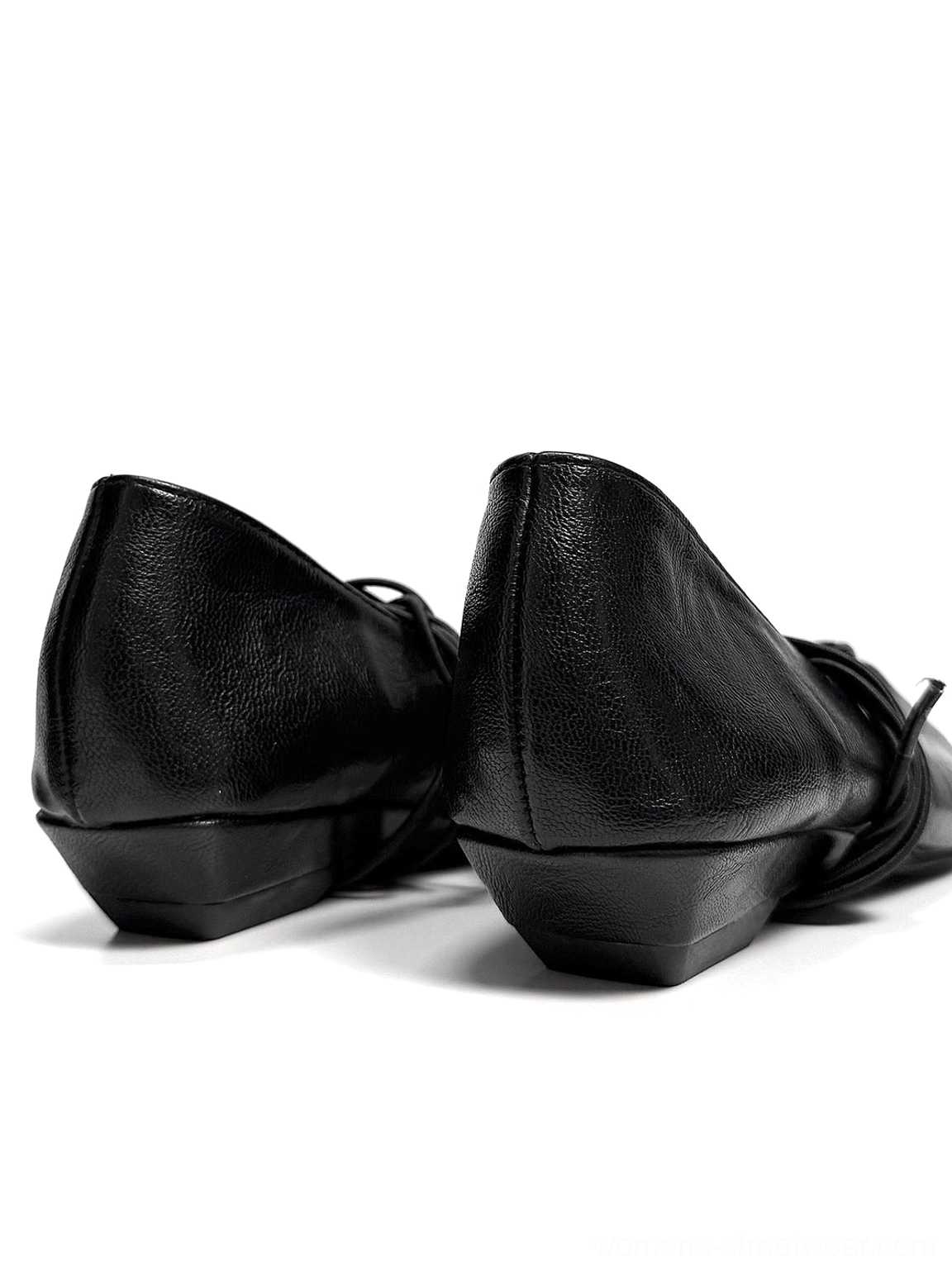 Rear side view of paired black lace-up Mary Jane flats showing low heels, smooth heel caps, and ankle-tied laces