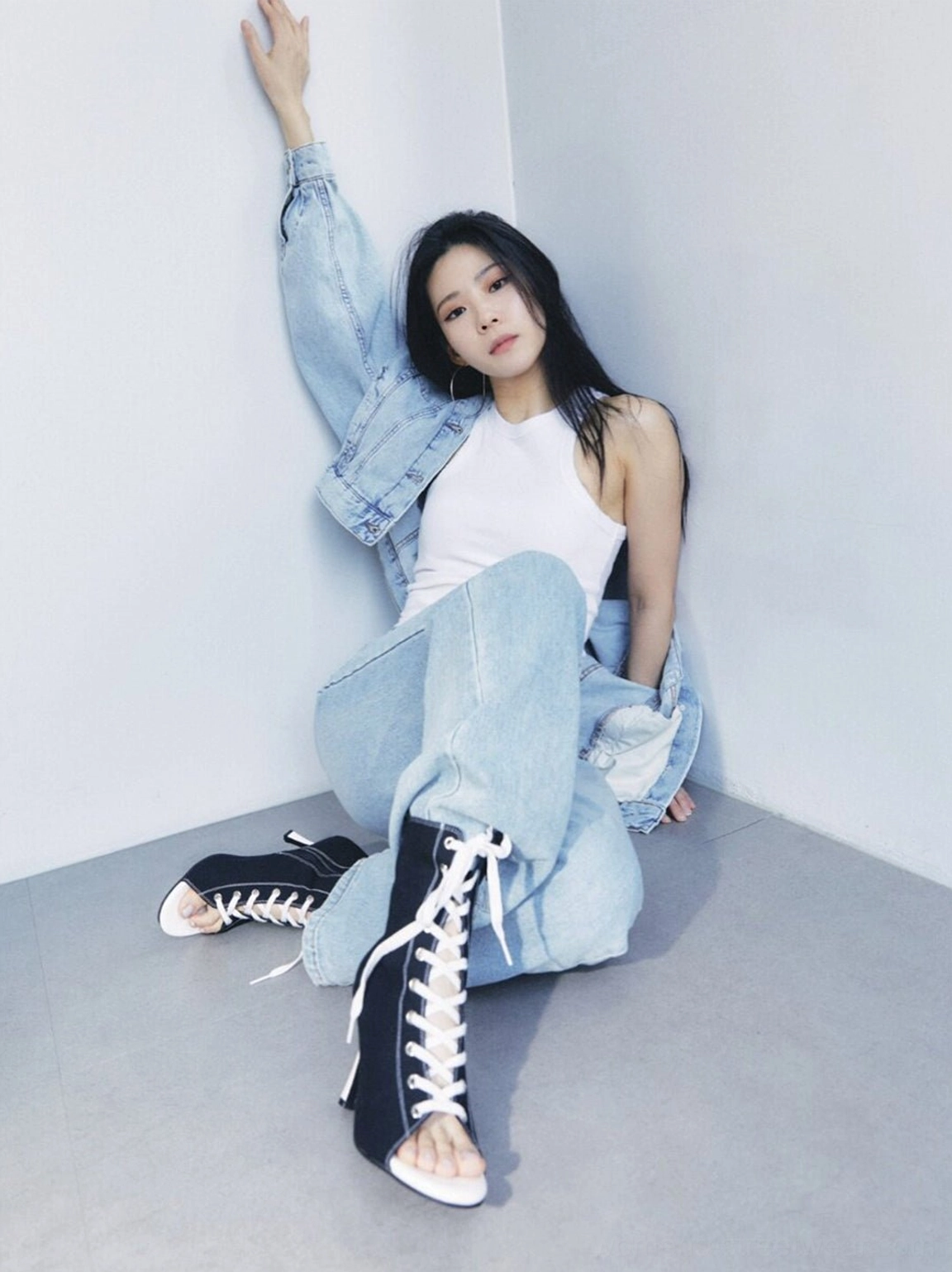 Model wearing black lace-up peep-toe stiletto ankle boots with jeans and denim jacket for a casual contemporary streetwear look