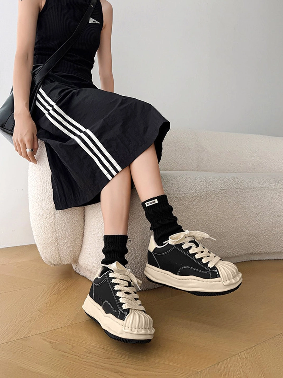 Black lace-up platform court sneakers with microfiber-leather upper, frayed panels, and structured streetwear silhouette