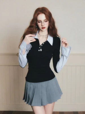 Black layered polo knit top with striped shirt collar and cuffs styled with a grey pleated skirt front view