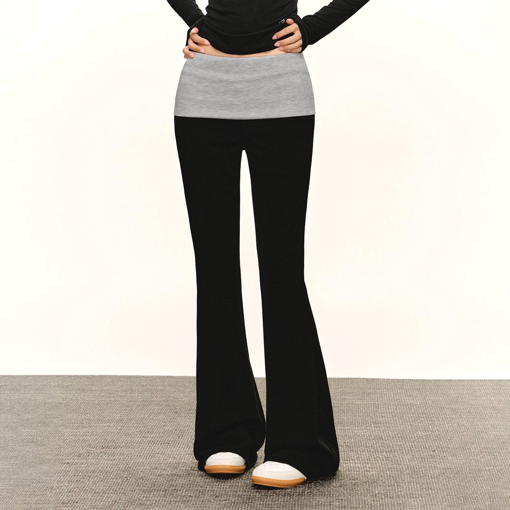 Black layered waistband flare leggings with a high rise foldover waistband styled with a fitted black top and two tone casual sneakers