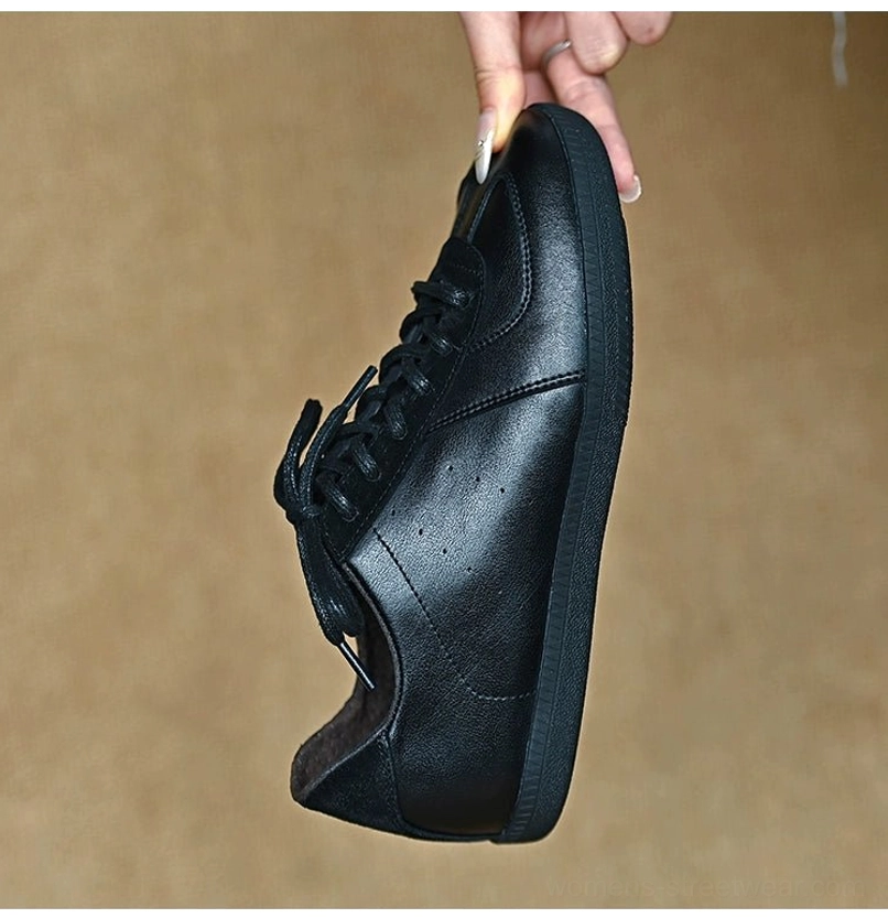 Rear three-quarter view of a black leather casual sneaker with clean paneling, secure laces, and streamlined urban styling