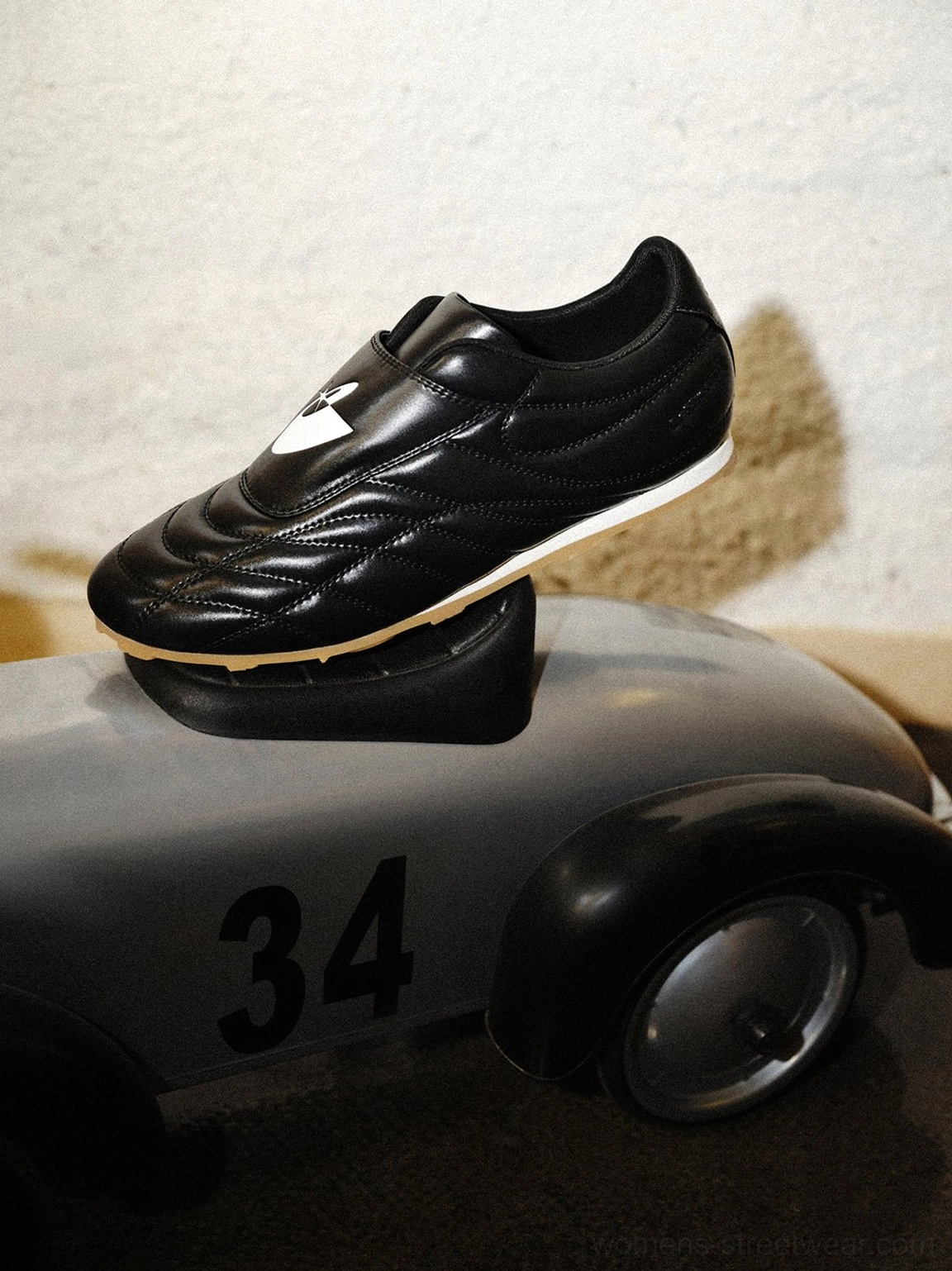 Black leather-look soccer trainer shoes with soft sheepskin insole, gum rubber outsole, and low-profile shape