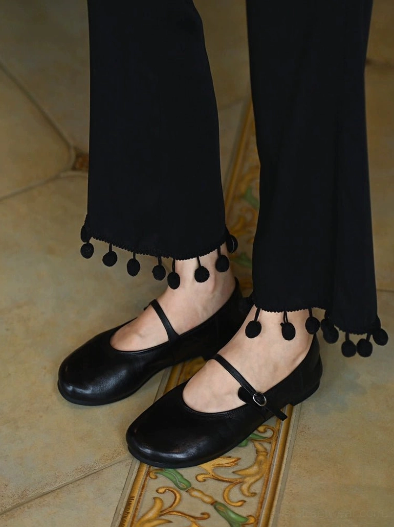 Front low angle view of matching black leather Mary Jane flats with rounded toe and minimalist flat sole
