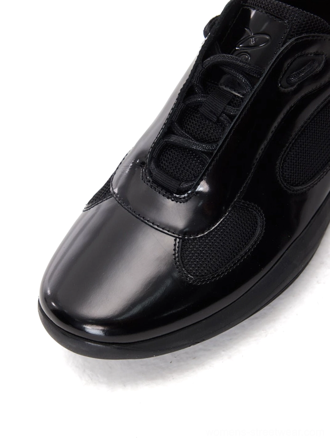 Front close-up of black leather and mesh retro runner sneaker with rounded toe and classic lace-up closure