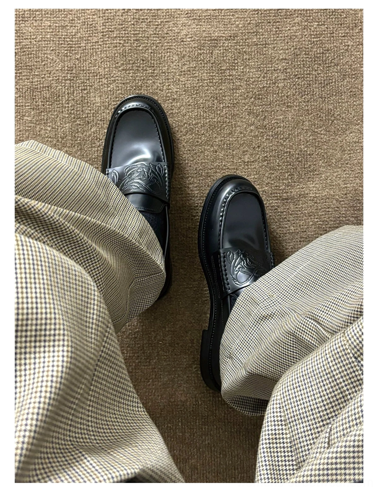 Black leather slip-on loafers featuring embossed vamp detailing, square-toe styling, burgundy lambskin lining, and a low rubber sole