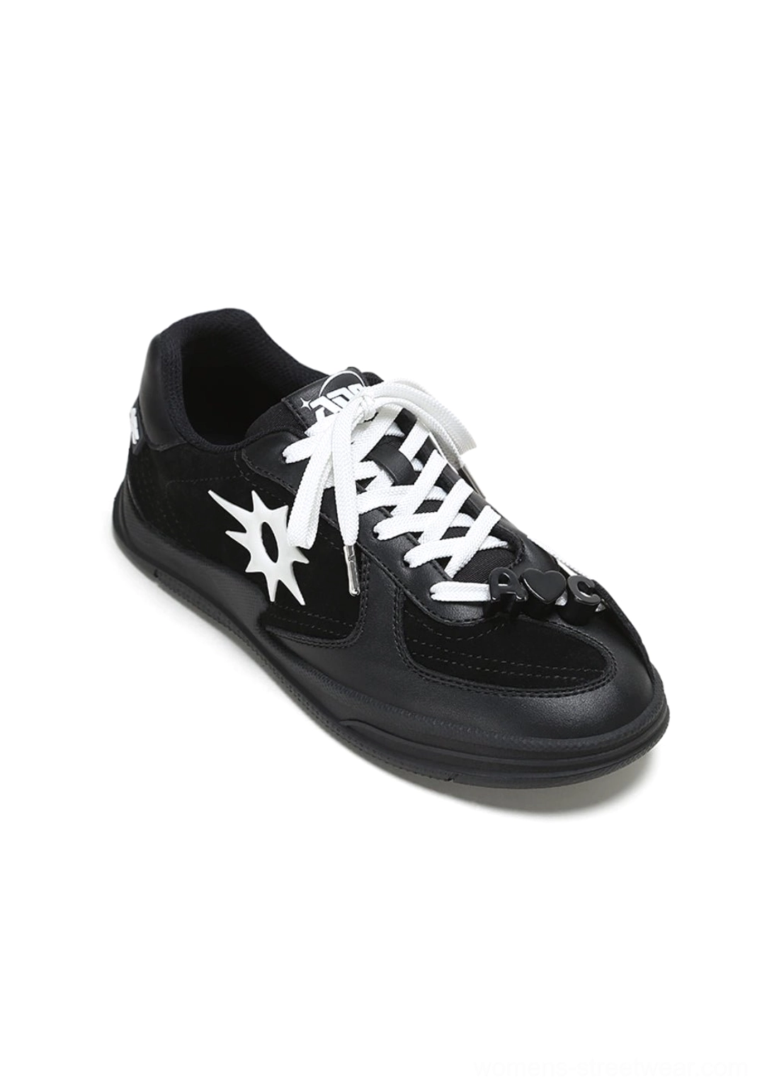 Side view of a black leather court sneaker with white solar star applique, white laces, and decorative lace charms