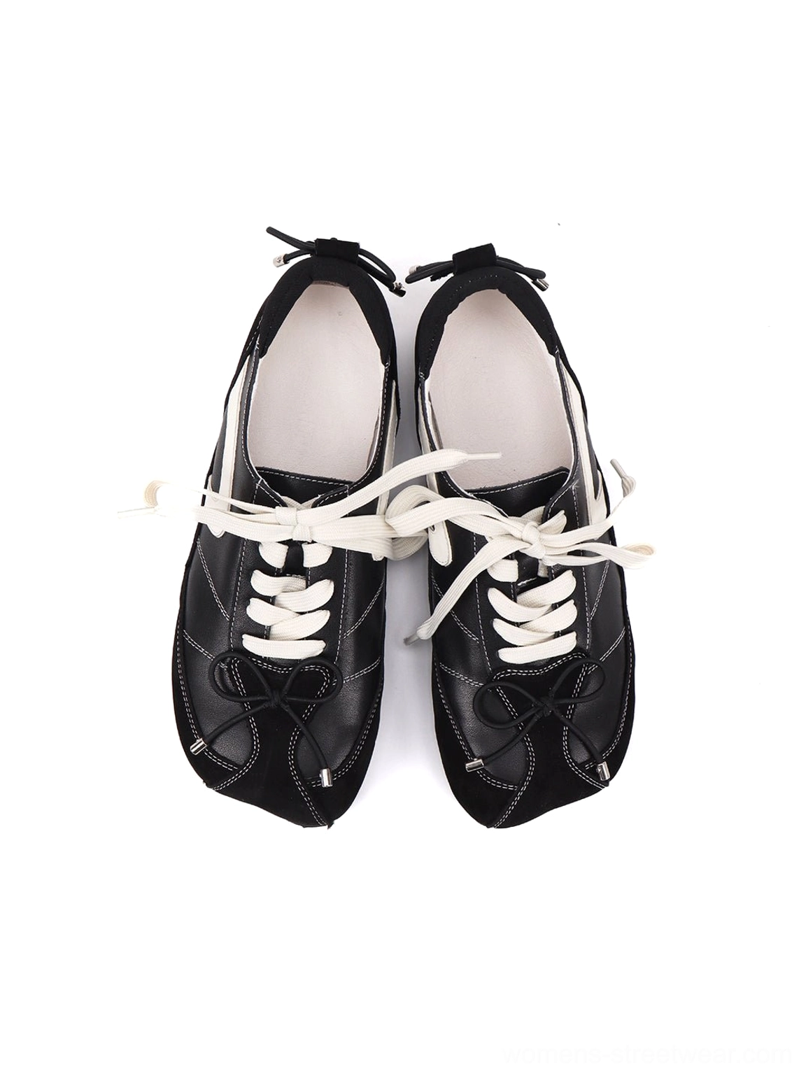 Top-down view of black leather square-toe ballet flats with white flat laces, smooth insoles, and rear heel details