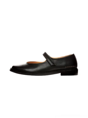 Black leather strap Mary Jane flats in left side profile with polished upper, soft square toe, and low block heel on a white background