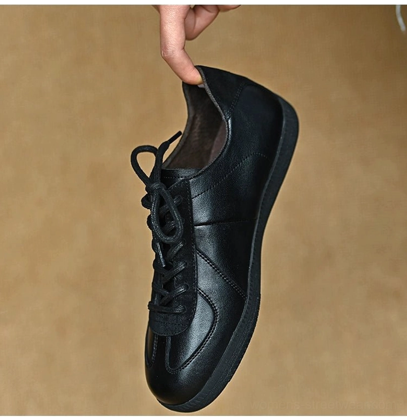Interior side view of a black leather streetwear sneaker showing the padded collar, smooth lining, and lace-up construction