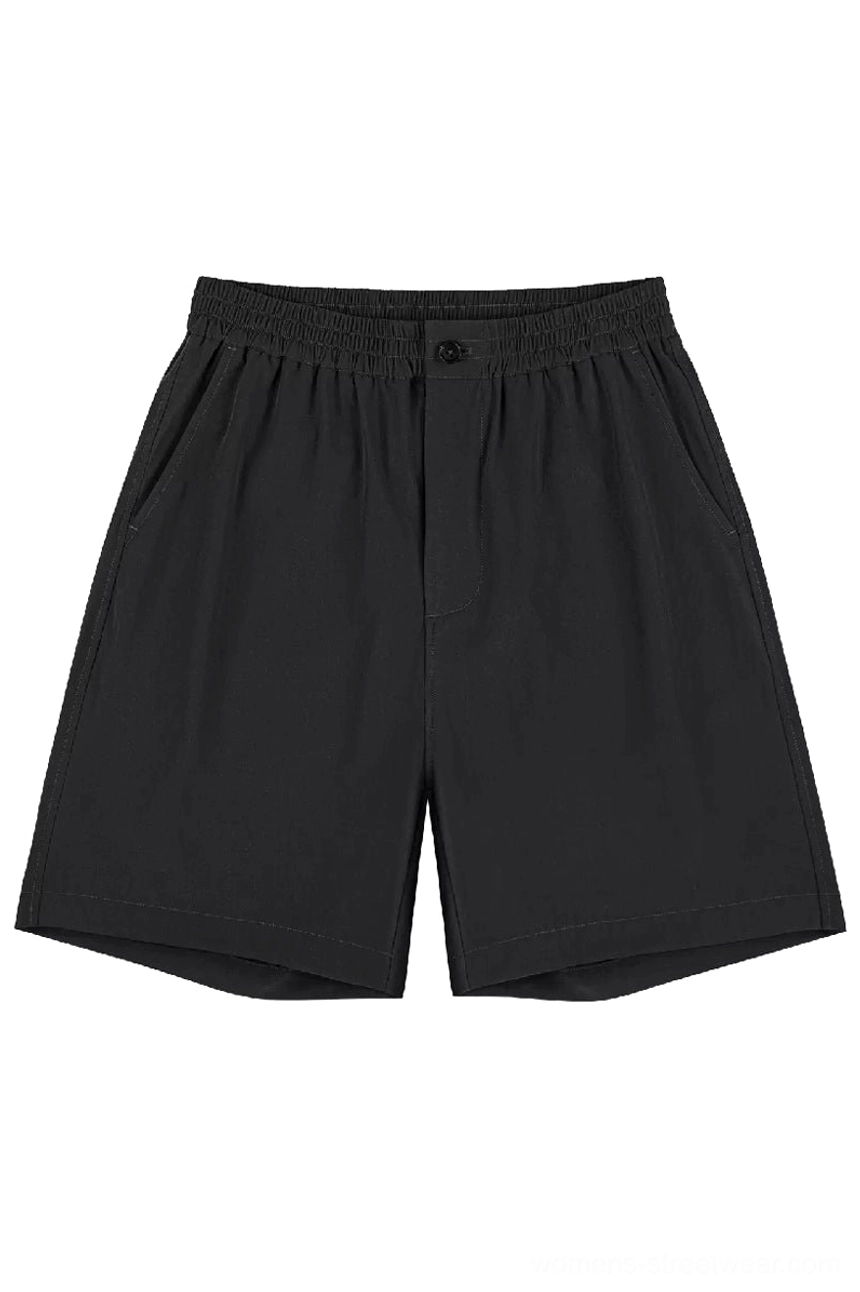 Black lightweight outdoor tech shorts with elastic waistband single button closure side pockets and relaxed straight leg streetwear silhouette