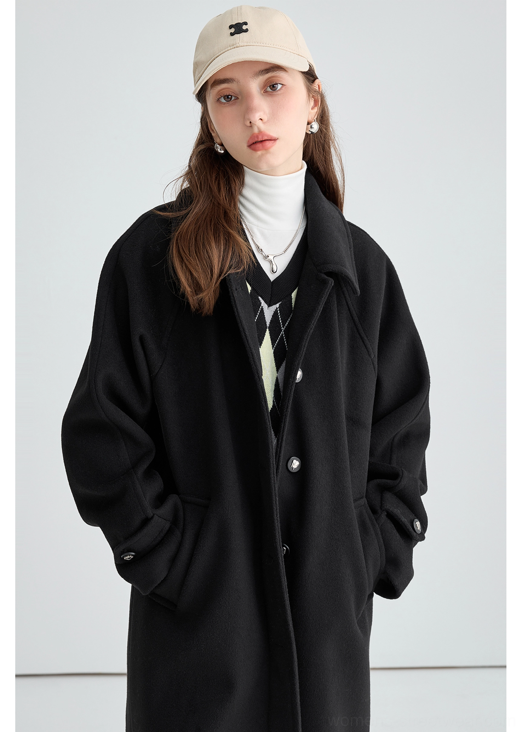 Black long insulated streetwear overcoat product image showing clean tailored black outerwear silhouette