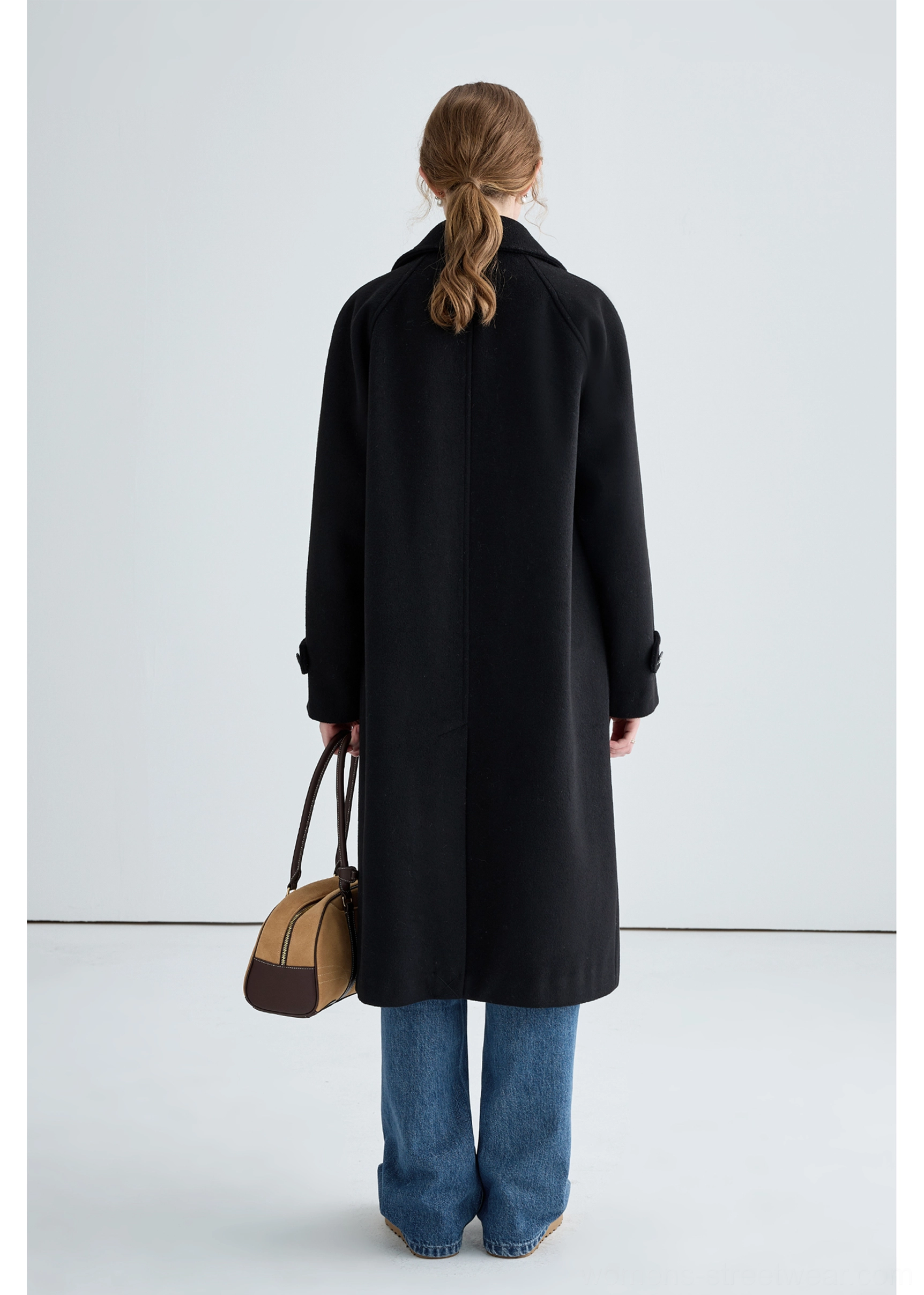 Black long insulated streetwear overcoat detail image highlighting the structured collar and button closure