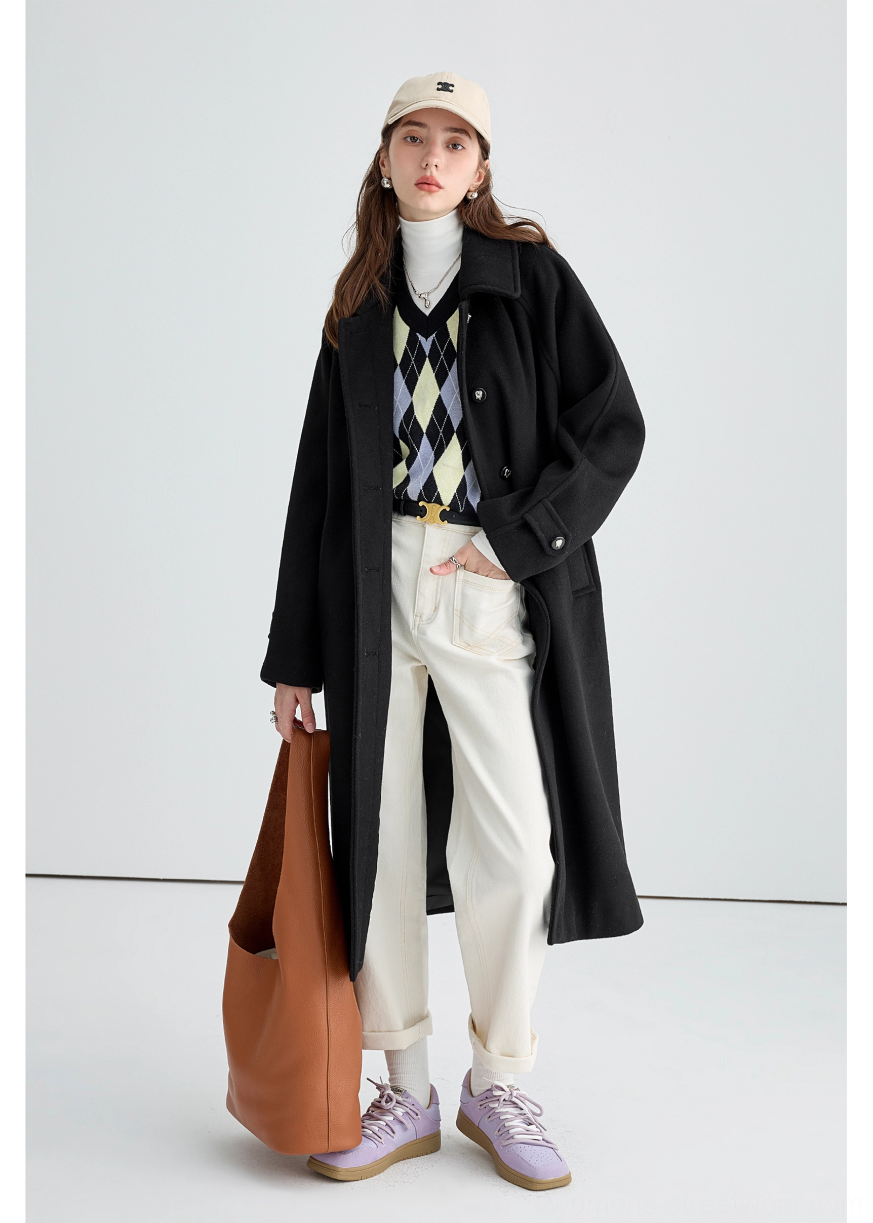 Black long insulated streetwear overcoat worn in a full front view with notched lapel and adjustable cuff straps