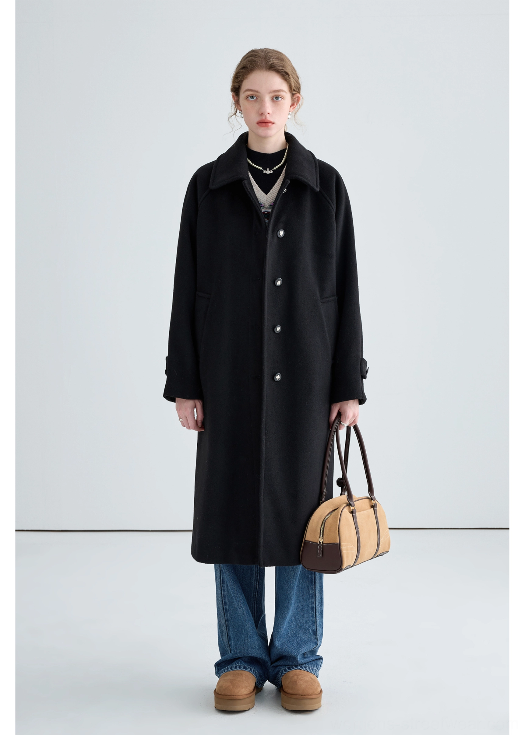 Black long insulated streetwear overcoat with a clean notched lapel and relaxed oversized winter layering fit