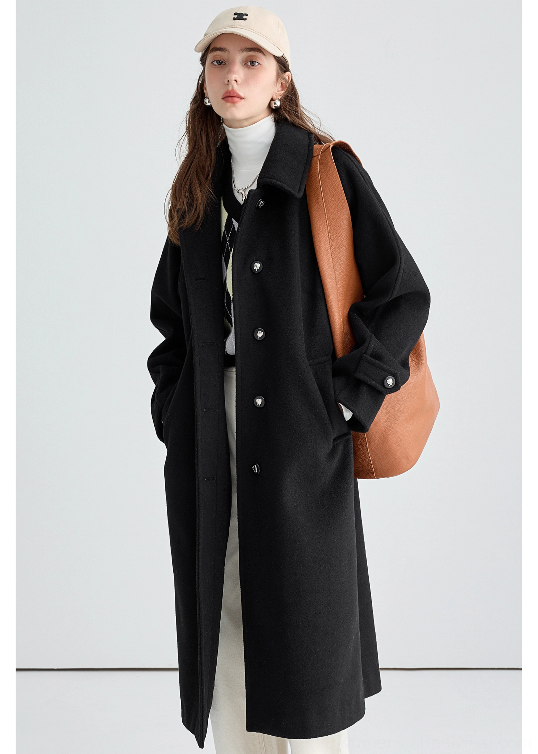 Side three-quarter view of black long insulated streetwear overcoat with clean lapel side pockets and long straight shape