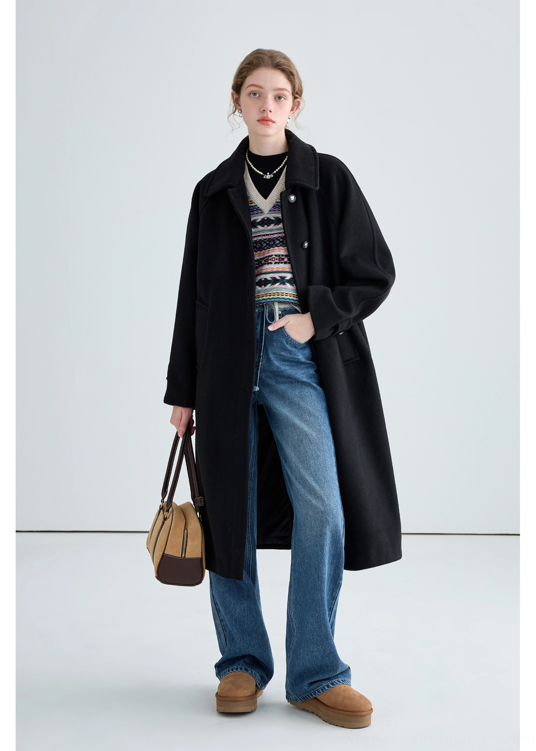 Black long insulated streetwear overcoat product detail view with tailored winter outerwear construction